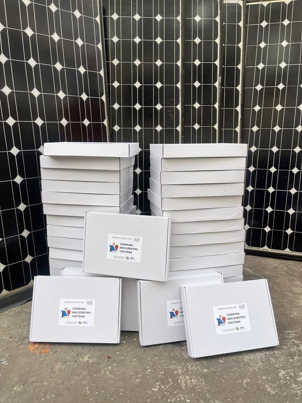 White boxes stacked in front of solar panels