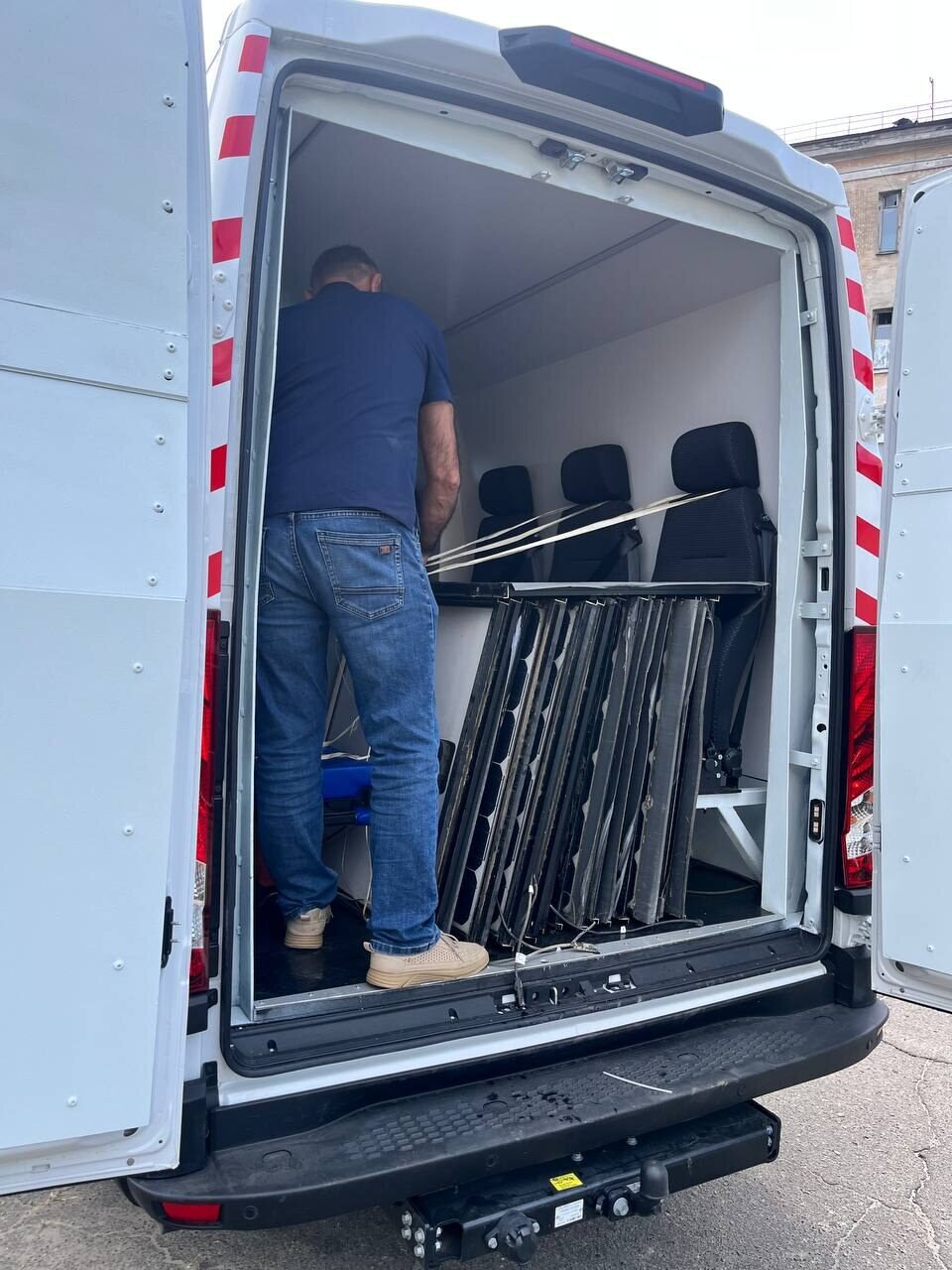 A man loads solar panels into a van